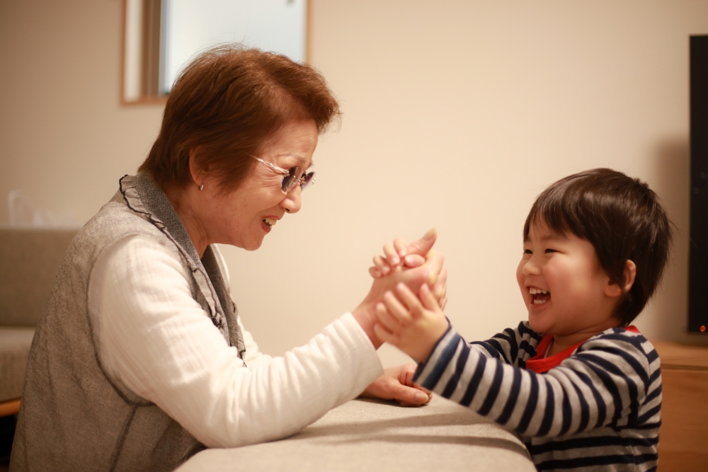 孫と室内遊びをする祖母